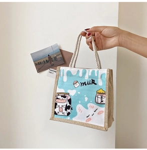 Detail of cute cow print canvas handbag with woven rope handles and blue-beige contrast