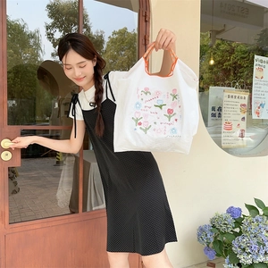 Detailaufnahme der bestickten Stofftasche mit Tulpenprint und karierten Trägern