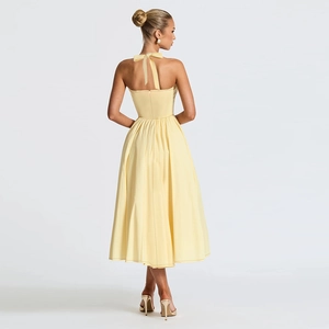 Back view of yellow satin halter dress showing elegant backless tie design and soft drapes