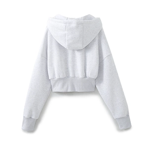 Back view of a light grey cropped hoodie featuring a large hood and ribbed knit hem details