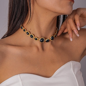 Detailed close-up of retro golden choker with black resin round geometric pendants on neck