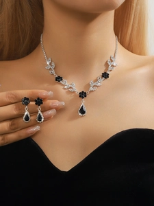 Detail of luxury bridal necklace and earrings set with black and white crystals