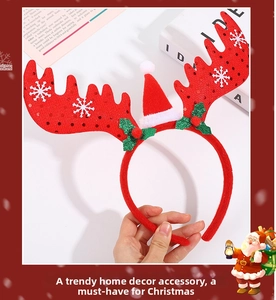 Detailed view of a red velvet Christmas headband with reindeer antlers and a mini Santa hat