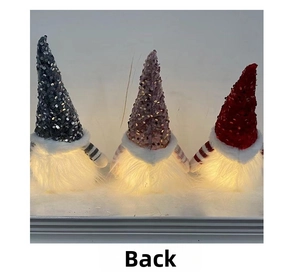 Rear view of three glowing Christmas gnomes with sequined hats and warm LED lights