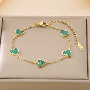 Detailed macro view of a gold heart bracelet featuring green malachite stone inlays