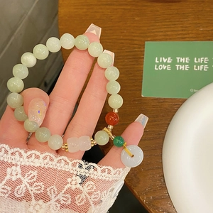 Retro 8mm celadon jade beaded bracelet with white safety buckle pendant on wrist