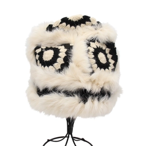 Close-up of crochet monster hat featuring black polka dots and thick white faux fur trim