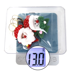 Close-up of a Santa Claus plush hanging ornament weighing 13g on a digital scale