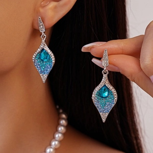 Detailed view of silver flower earrings with vintage blue rhinestones and faux pearls