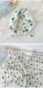 Detail showing pink floral print on white cotton scarf and elegant knotted style