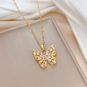 Luxury gold butterfly necklace with crystal pavé stones on a soft silk background