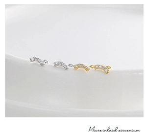 Macro shot of micro-inlaid zircon curved stud earrings in silver and gold plating