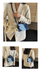Détail du sac à main en patchwork de denim avec textures bleues et pendentif en peluche