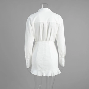 Back view of white long-sleeved shirt dress showing pleated details and ruffle hemline