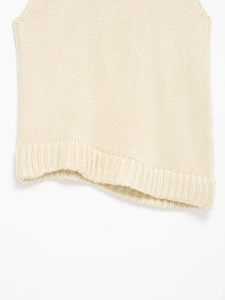 Detailed macro view of the cream knit vest hem featuring high-quality ribbed texture