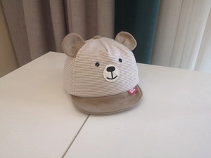 Detail of baby bear baseball cap showing khaki striped cotton fabric and cute 3D ears