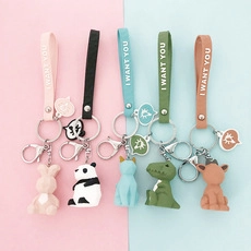 Detail of cartoon animal keychains with leather straps featuring rabbit and panda designs