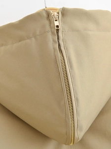 Close-up of golden metal zipper and premium khaki twill fabric on women's parka jacket