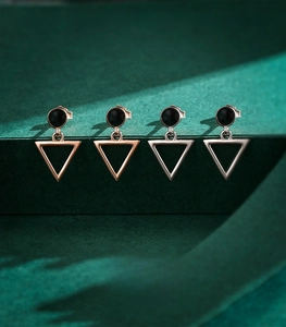 Macro view of geometric S925 sterling silver triangle earrings in silver and rose gold