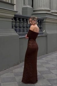 Detailed close-up of intricate crochet knit pattern on an off-shoulder brown maxi dress