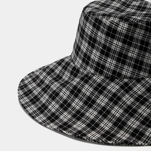 Close-up of black and white plaid bucket hat showing textured cotton fabric weave