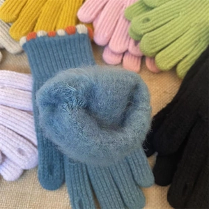 Dettaglio ravvicinato di guanti in maglia con fodera in peluche e foro per il pollice