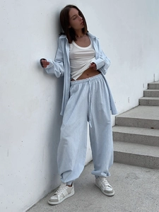 Detail of light blue striped shirt and drawstring trousers with high-waist elastic band