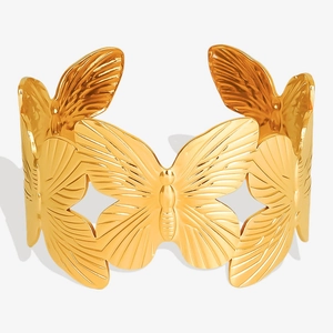 Macro del bracciale rigido a farfalla placcato oro 18K con dettagli sulle ali ampie
