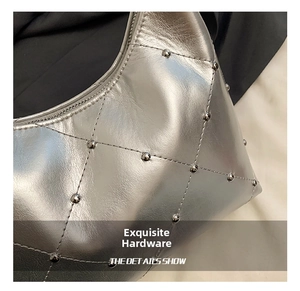Gros plan sur le sac en cuir argenté avec motif matelassé et clous métalliques