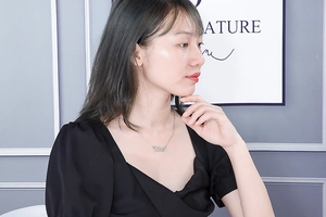 Detailed view of silver Libra zodiac pendant necklace worn by a fashion model