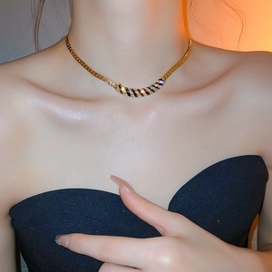 Detail shot of vintage gold snake chain necklace with black striped rhinestone pendant