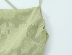 Detailansicht von minzgrünem Jacquard-Stoff mit Rosenmuster und feinen Trägern am Kleid