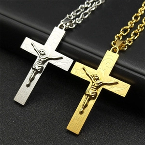 Détail macro de pendentifs triple croix or et argent avec relief de Jésus sur chaînes