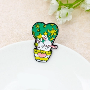 Cartoon bunnies in a colorful hot air balloon enamel pin on a white ceramic tray