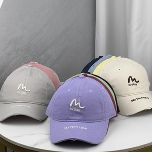 Macro shot of embroidered letters and distressed brim details on cotton baseball caps