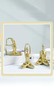 Detailed close-up of golden abstract yoga girl figurines in modern ceramic style