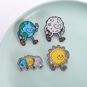 Cartoon enamel pin set featuring walking sun, earth, and moon figures in a green tray