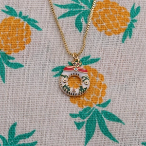 Christmas wreath necklace with colorful gems and red bow on a gold chain
