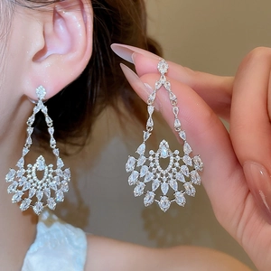Detailed macro view of silver floral drop earrings with marquise-cut zircon stones