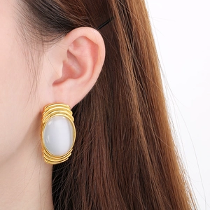 Detailed close-up of French-style gold stainless steel earrings with white oval opal stones