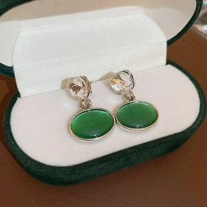 Macro shot of vintage earrings with green oval stones in a velvet gift box