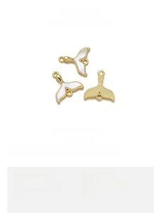 Macro detail of 18K gold plated copper fishtail charms with natural shell inlays