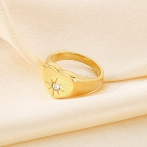 Makroaufnahme: Herz-Siegelring in Gold mit Sternschliff-Diamant auf Satin-Hintergrund