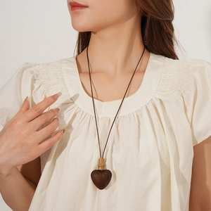 Close-up of a model wearing a New Chinese style wooden heart pendant necklace with cord