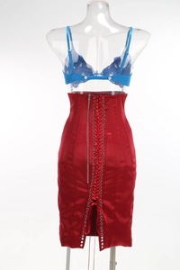Détail d'une jupe rouge satinée à taille haute avec lacets au dos et fermeture éclair