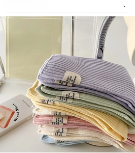 Détail de chaussettes en coton côtelé aux couleurs macaron avec étiquette en tissu décorative