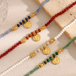 Détail de bracelets vintage en or 18K avec pendentifs pièces et pierres naturelles