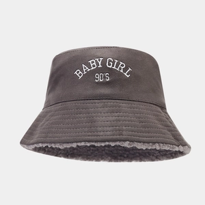 Detail of embroidered 'BABY GIRL 90'S' text on grey suede warm winter bucket hat