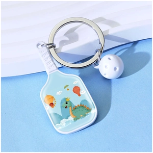 Pickleball paddle keychain with cartoon dinosaur print, white ball and silver metal ring
