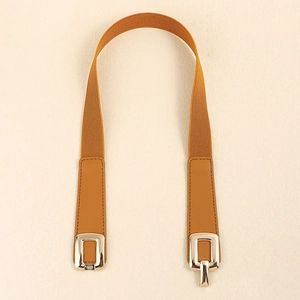Detailed macro view of brown elastic waist belt with gold square buckle and leather ends